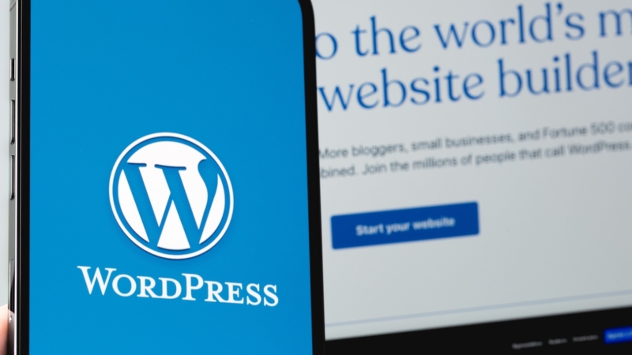 Blue and white WordPress logo on a mobile device screen next to WordPress homepage on a laptop screen Blue and white WordPress logo on a mobile device screen next to WordPress homepage on a laptop screen