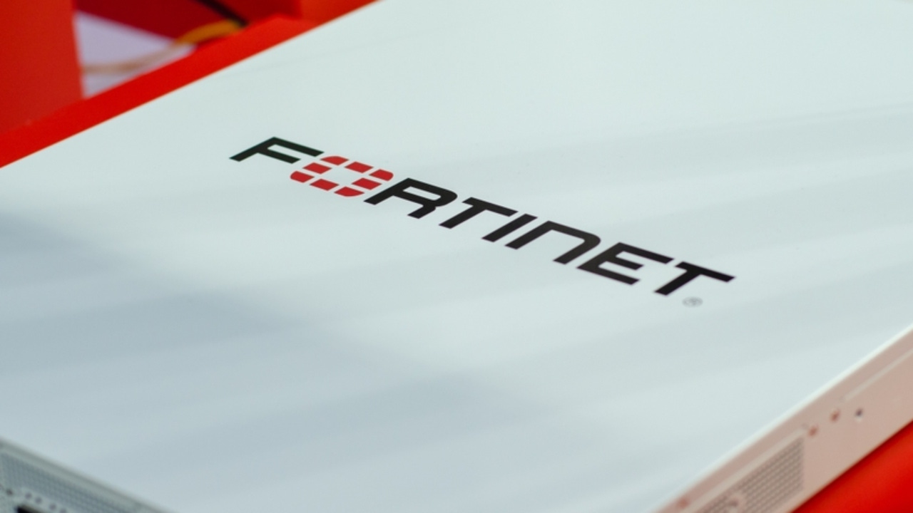 A white device with the word Fortinet written on it against a red background A white device with the word Fortinet written on it against a red background