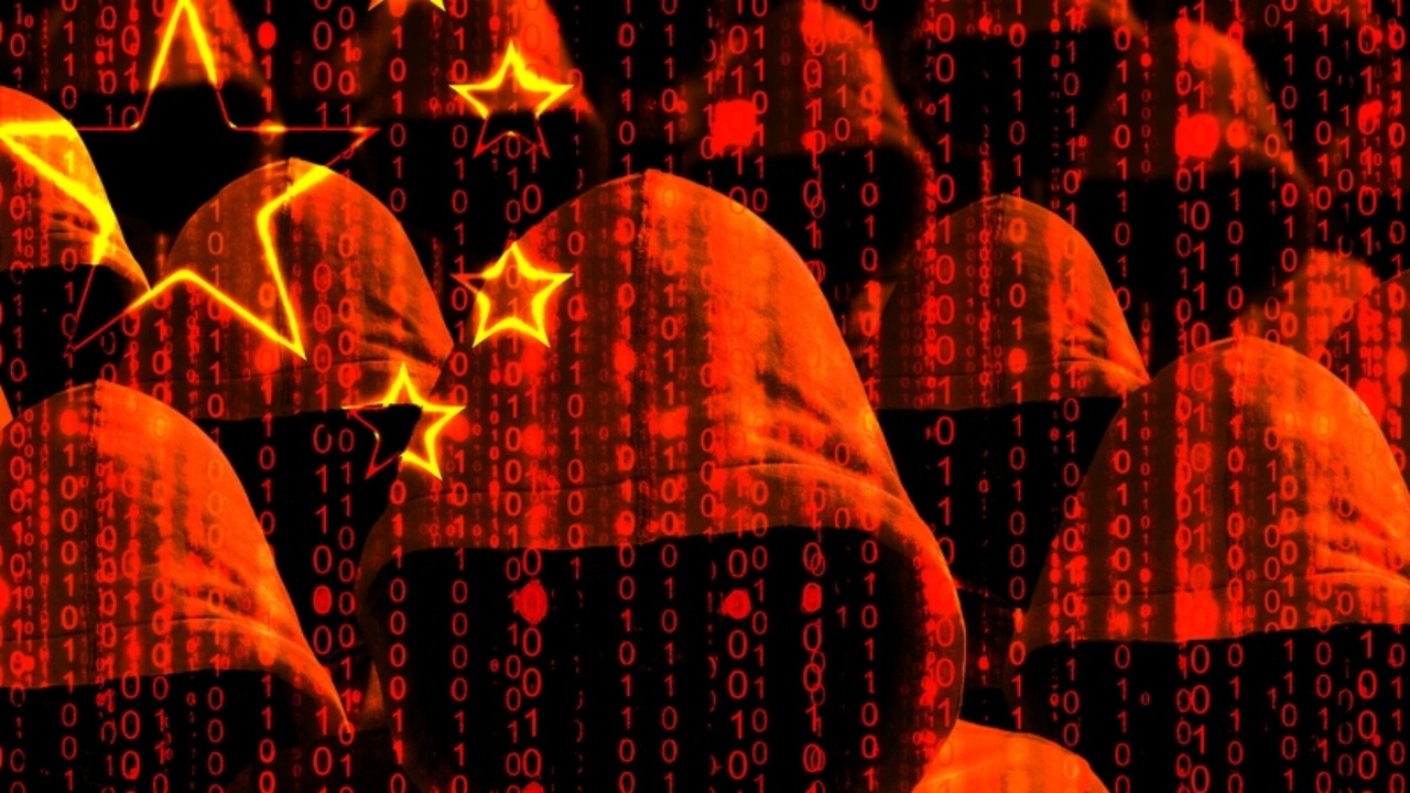 A series of figures in hoods washed in red against lines of code with several yellow stars on the upper left corner A series of figures in hoods washed in red against lines of code with several yellow stars on the upper left corner