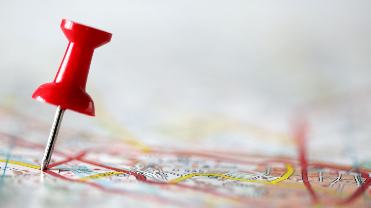 A red pushpin pinpointing a location on a map