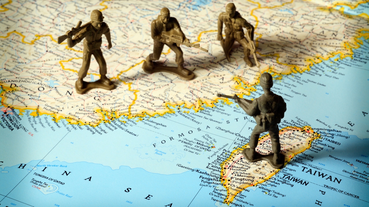 Little toy soldiers facing one another over a map of China and Taiwan Little toy soldiers facing one another over a map of China and Taiwan