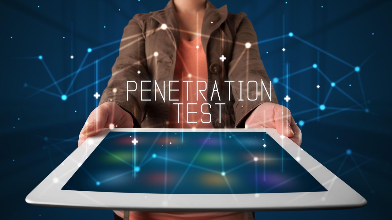 Person holing a tablet; above the tablet, the words "PENETRATION TEST"