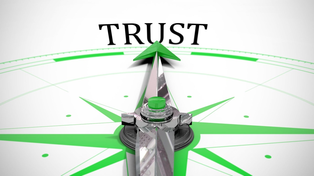 Close-up of a compass face; north is marked TRUST, and the needle is pointe toward it Close-up of a compass face; north is marked TRUST, and the needle is pointe toward it