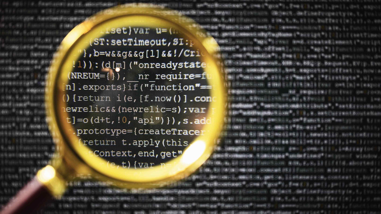 A screen full of code with a magnifying glass over it. A screen full of code with a magnifying glass over it.