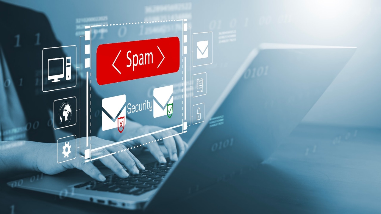 Person looking at laptop screen, sorting email; one is marked SPAM Person looking at laptop screen, sorting email; one is marked SPAM